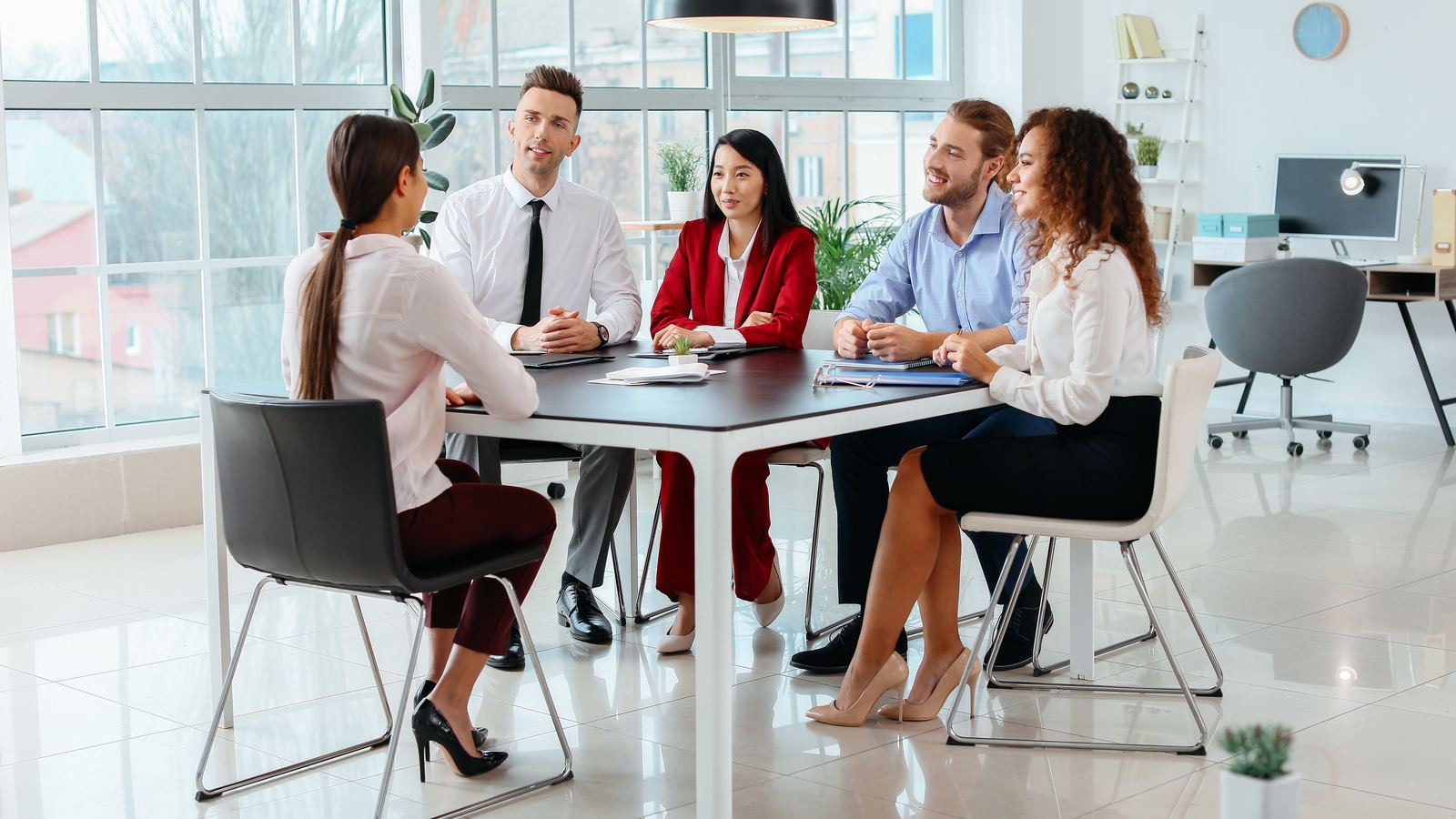 An HR team meeting around a table in a bright office
