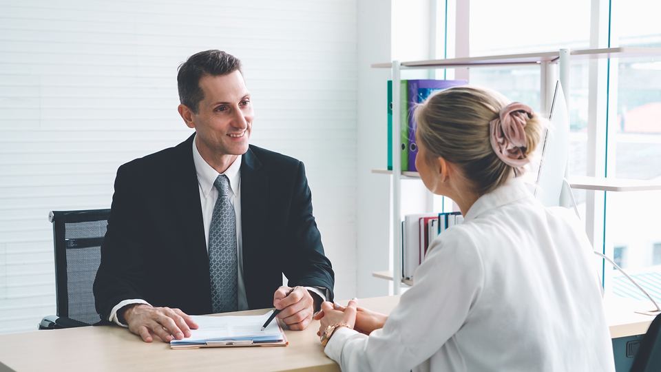 An HR manager interviewing a candidate across a desk