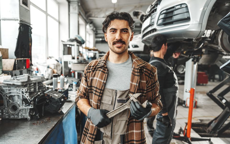 A technician holding a wrench in the service shop